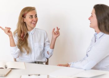 smiley-women-communicating-with-each-other-through-sign-language
